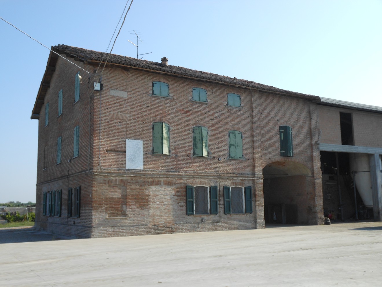 Lapide commemorativa dedicata alla famiglia Epimio Bonini su un edificio storico di mattoni.