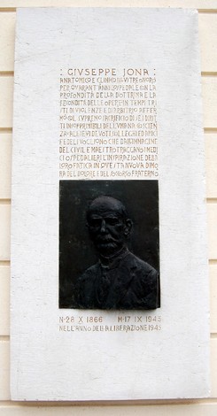Lapide commemorativa dedicata a Giuseppe Jona, con un rilievo in bronzo e testo descrittivo in alto.