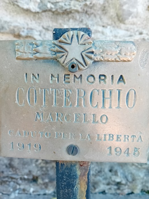 Monumento in memoria di Marcello Cotterchio, caduto per la libertà nel 1945, con simboli commemorativi.