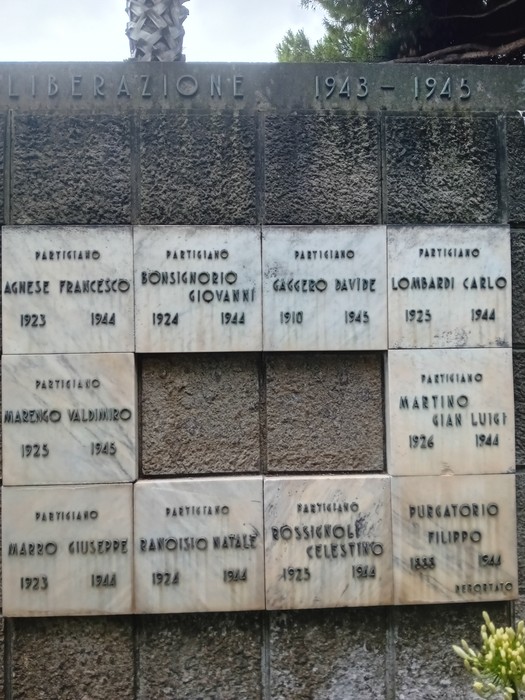 Monumento ai caduti con targhe commemorative di partigiani, in un contesto di rispetto e memoria storica.