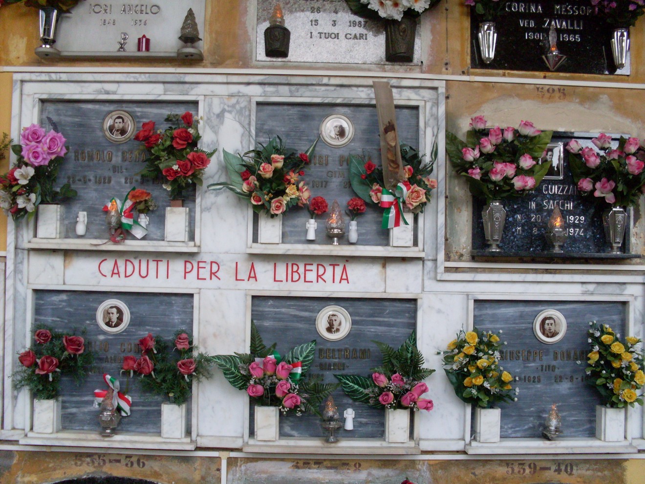 Sacrario dedicato ai caduti per la libertà, decorato con fiori e candele. Omaggio alla memoria dei valorosi.
