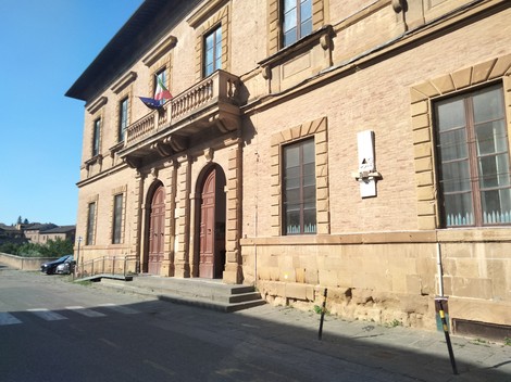 Lapide commemorativa dedicata alle sorelle Nissim su un edificio storico con facciata in mattoni.