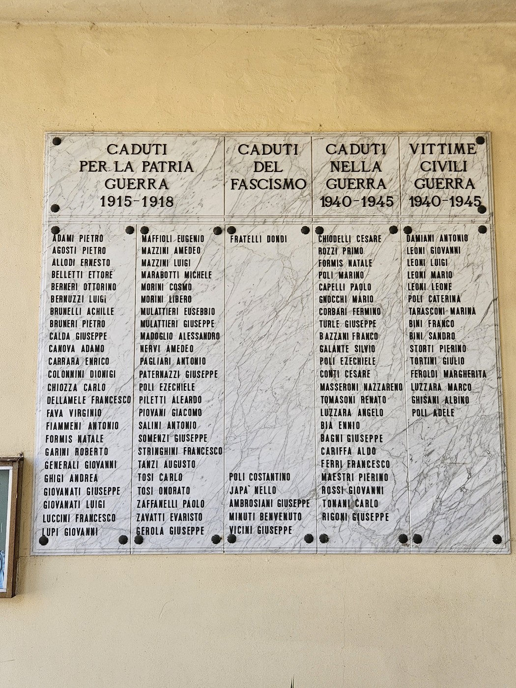 Lapide commemorativa che elenca i nomi dei caduti in guerra tra il 1915 e il 1945.