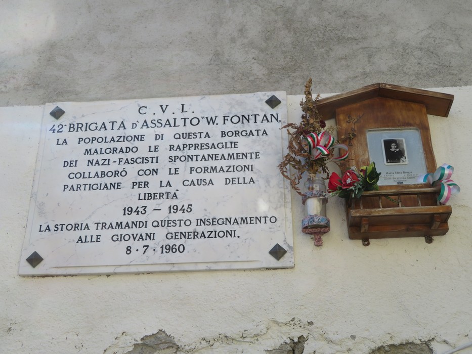 Lapide commemorativa della Resistenza con dettagli decorativi e un ritratto, dedicata alla 42ª Brigata d'Assalto.