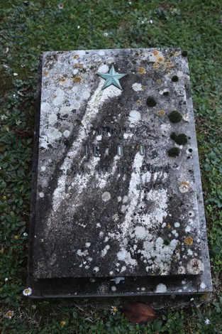 Tomba in memoria dei partigiani pratesi, con decorazioni e simboli commemorativi.