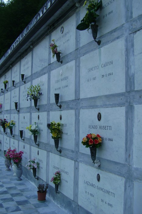 Sepolcri dedicati ai caduti per la libertà, decorati con fiori in un luogo di commemorazione e rispetto.
