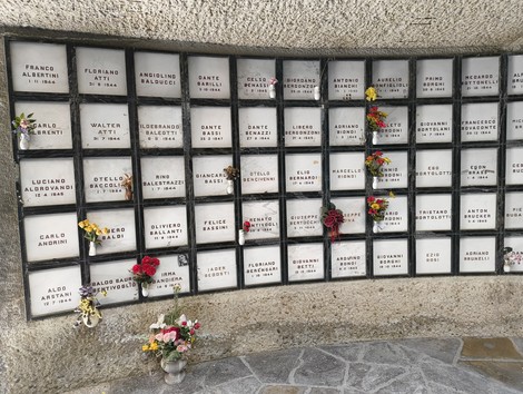 Monumento Ossario dei caduti partigiani, con lastre commemorative e fiori commemorativi.