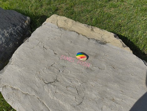 Monumento in memoria dei partigiani caduti, situato a Monte Sabbiuno, con roccia e decorazioni colorate.
