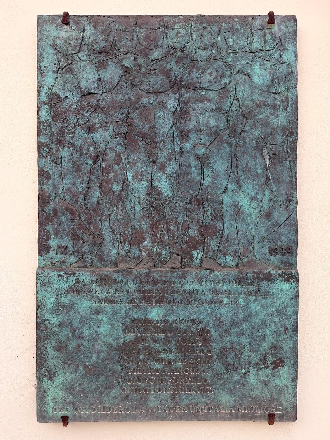 Targa in bronzo su parete, con figure in rilievo nella parte superiore e iscrizione nella parte inferiore.