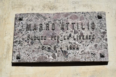 Lapide commemorativa dedicata a Marro Attilio, caduto per la libertà, murata su una parete.