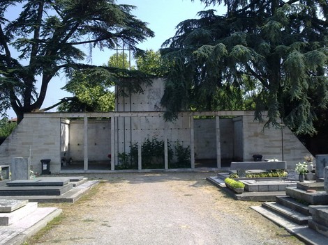 Monumento ai Caduti Partigiani, memoriale situato in un cimitero circondato da alberi e lapidi.