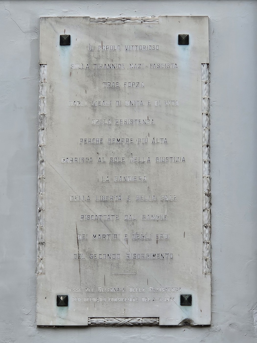 Lapide commemorativa dedicata alla Resistenza, con iscrizioni eloquenti sul valore della libertà e della giustizia.