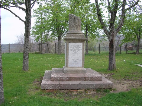 Monumento ai caduti e ai deportati, situato in un'area verde circondata da alberi.