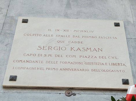 Lapide commemorativa in memoria di Sergio Kasman, vittima del fascismo, situata in un luogo pubblico.