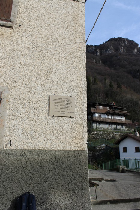 Lapide commemorativa del comando della brigata 24 maggio su una parete di un edificio in un contesto montano.