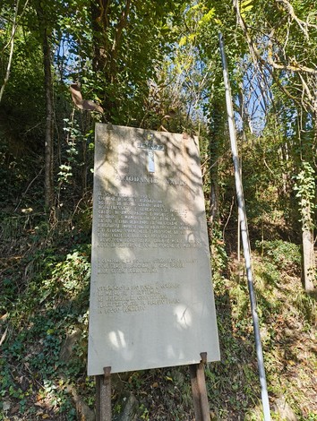 Monumenti a Naldi: una targa commemorativa immersa nella natura, simbolo di storia e memoria locale.