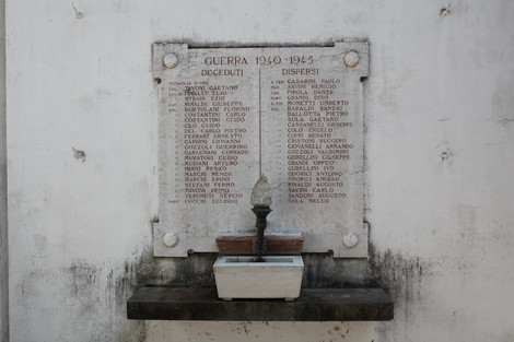 Monumento commemorativo con i nomi dei caduti e dispersi della guerra 1940-1945, situato su una parete scolpita.
