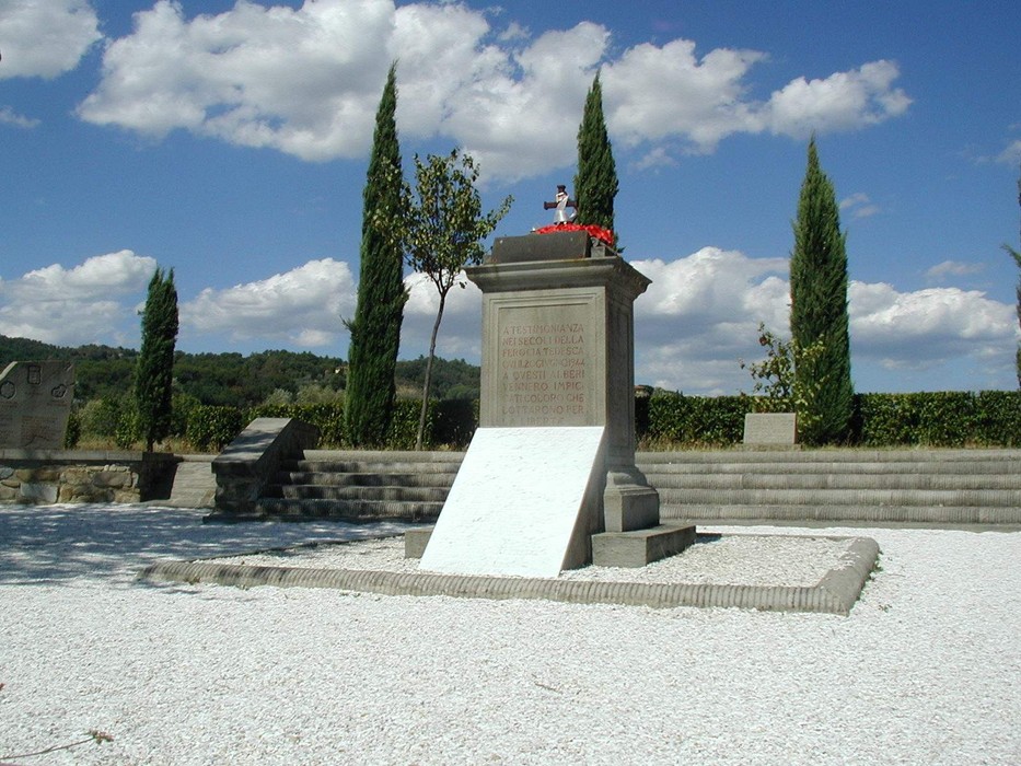 Monumento di Sant'Andrea circondato da cipressi e un cielo sereno, in un'area tranquilla e storica.
