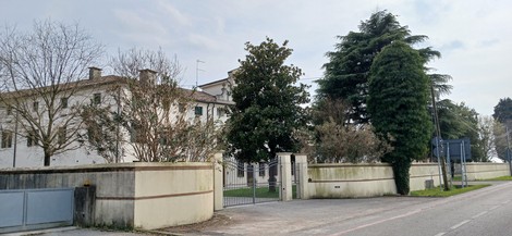 Lapide commemorativa all'esterno della casa natale dei fratelli Agosti, circondata da un giardino curato.