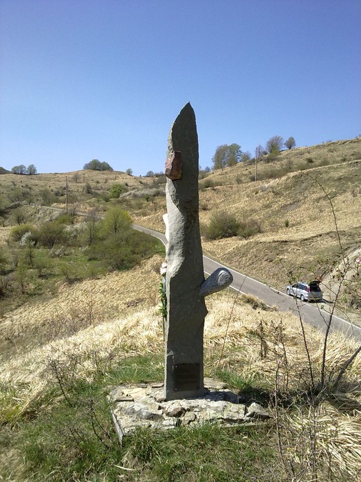 Monumento commemorativo a Fiorini, Giovannini e Donadelli, situato in un paesaggio collinare.