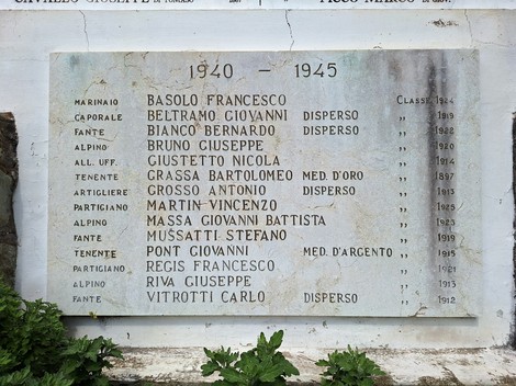 Lapide in pietra fissata a una parete, con un’iscrizione commemorativa e un elenco di nomi.