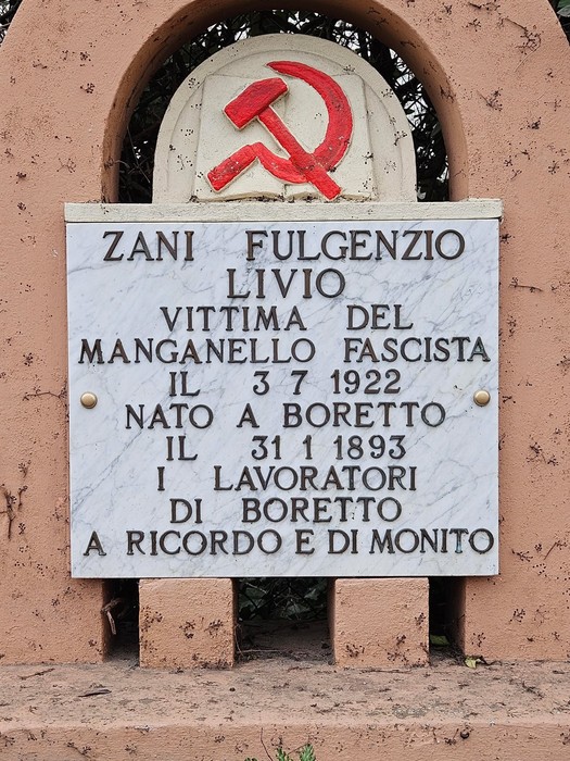 Cippo commemorativo dedicato a Zani Fulgenzio, vittima del fascismo, situato in un contesto naturale.