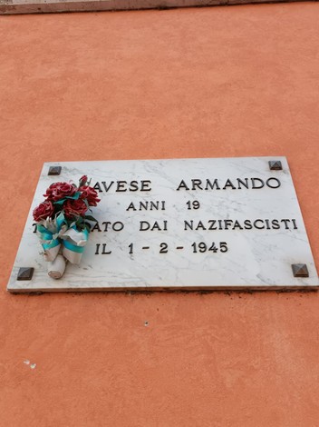 Lapide commemorativa dedicata a Armando Canavese, vittima dei nazifascisti nel 1945. Fiori posti in memoria.