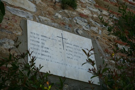 Lapide commemorativa sulla facciata della Casa Silvestri, decorata con una croce e nomi di familiari.