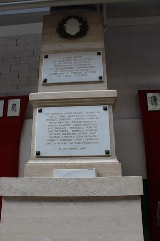 Monumento ai caduti dell'Ansaldo Elettrotecnico, con inscrizioni commemorative e decorazioni floreali.