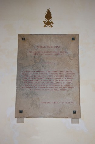 Lapide commemorativa del I Battaglione mobilitato, con simboli militari e dedica ai caduti.