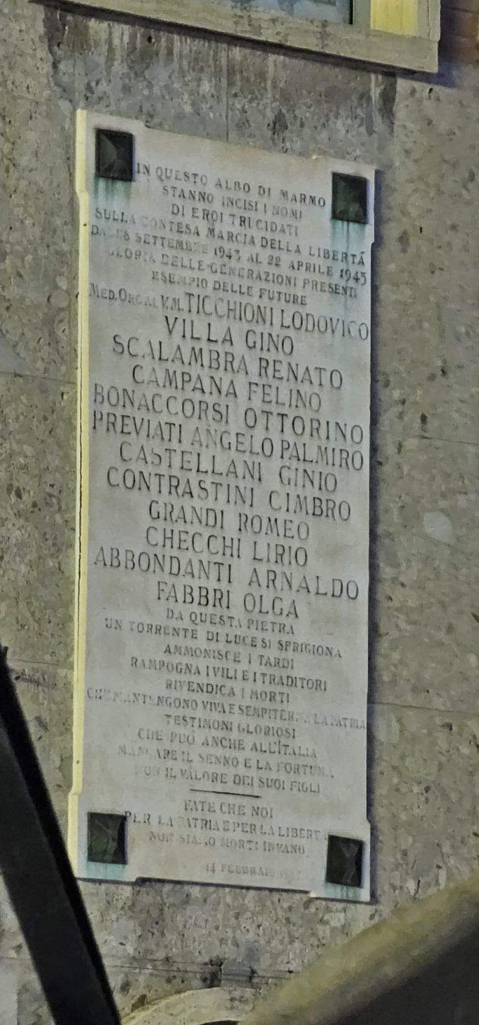Lapide commemorativa dedicata ai caduti per la Libertà, con nomi e onorificenze incisi in memoria.