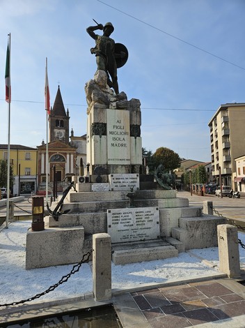 Monumento ai Caduti con statua centrale e iscrizioni commemorative in una piazza cittadina.