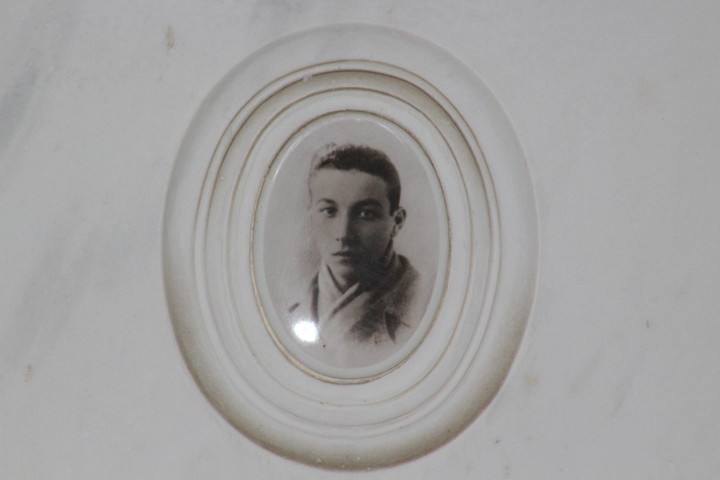 Ritratto di un giovane partigiano in un ovale bianco, in memoria dei combattenti per la libertà.