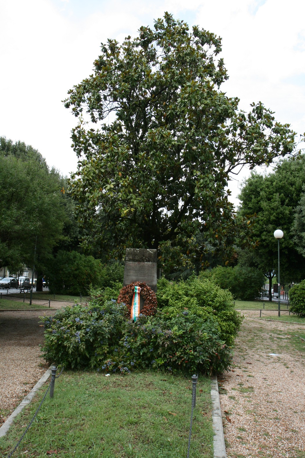 Cippo commemorativo dedicato ai caduti della Liberazione, adornato da un omaggio floreale.