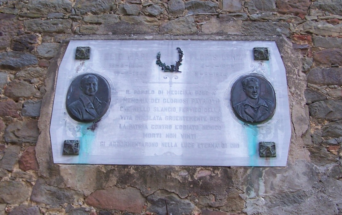 Lapide commemorativa dedicata a Mari e Lenzi, con ritratti e simboli di onore e memoria.