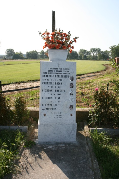 Cippo del Piaggione: monumento in memoria di famiglie del territorio, ricco di simboli e fiori commemorativi.