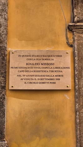 Lapide commemorativa dedicata a Ignazio Missoni, primo sindaco di Tivoli e partigiano, affissa su una parete.