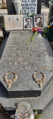 Sepolcro di Corsaro, decorato con fotografie e omaggi floreali, rispecchia la memoria e il dolore di una perdita.