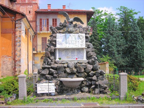 Monumento ai caduti di Vandorno, con statue e iscrizioni su un basamento di pietre. Un tributo alla memoria.
