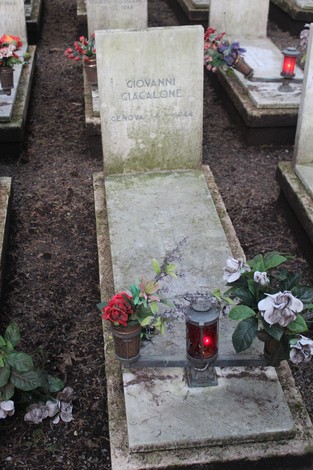 Tombe decorate con fiori e candele in un cimitero dedicato ai caduti per la Libertà.