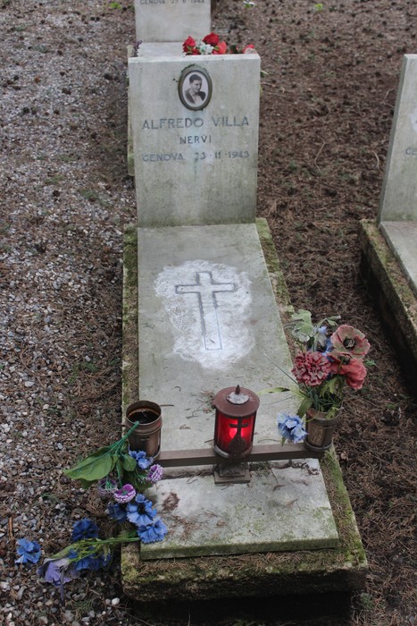 Tombe perpetue dedicate ai caduti per la Libertà, adornate con fiori e candele, in un cimitero tranquillo.