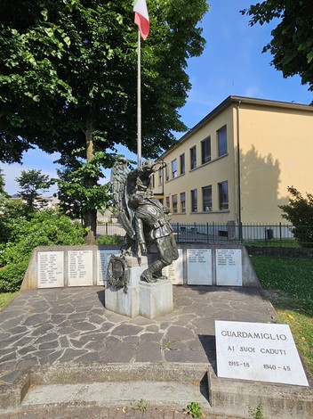 Monumento ai Caduti di Guardamiglio, con statua e targhe commemorative, immerso nel verde.