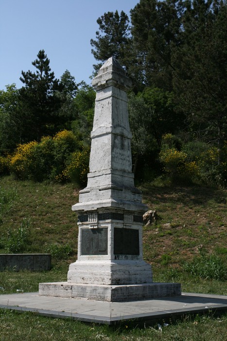Obelisco nel Parco dell'Aringhese, circondato da vegetazione, simbolo di memoria storica e bellezza naturale.