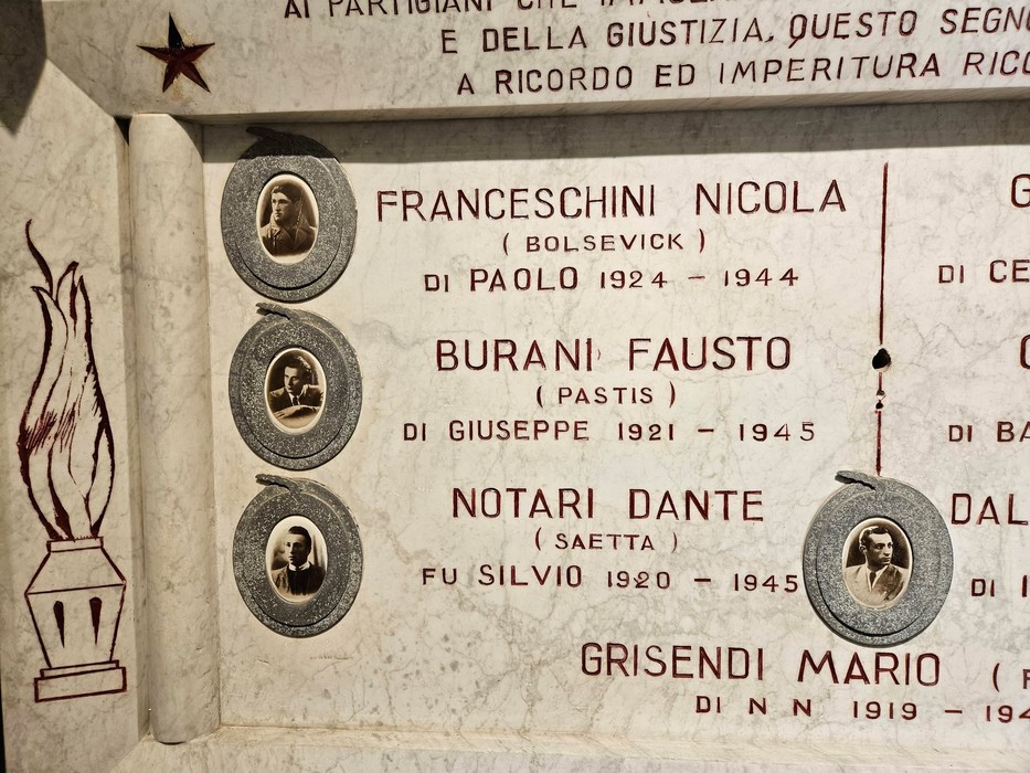 Lapide commemorativa ai caduti di San Polo, con nomi e fotografie dei defunti incisi nella pietra.
