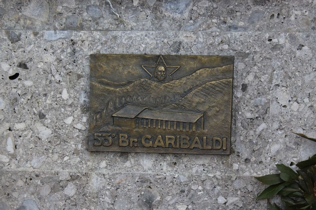 Monumento ai fratelli Pellegrini, dedicato alla memoria dei partigiani, con decorazioni e simboli storici.