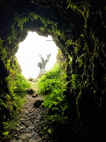 Monumento al Partigiano, simbolo della Resistenza, immerso nella natura e circondato da una grotta.