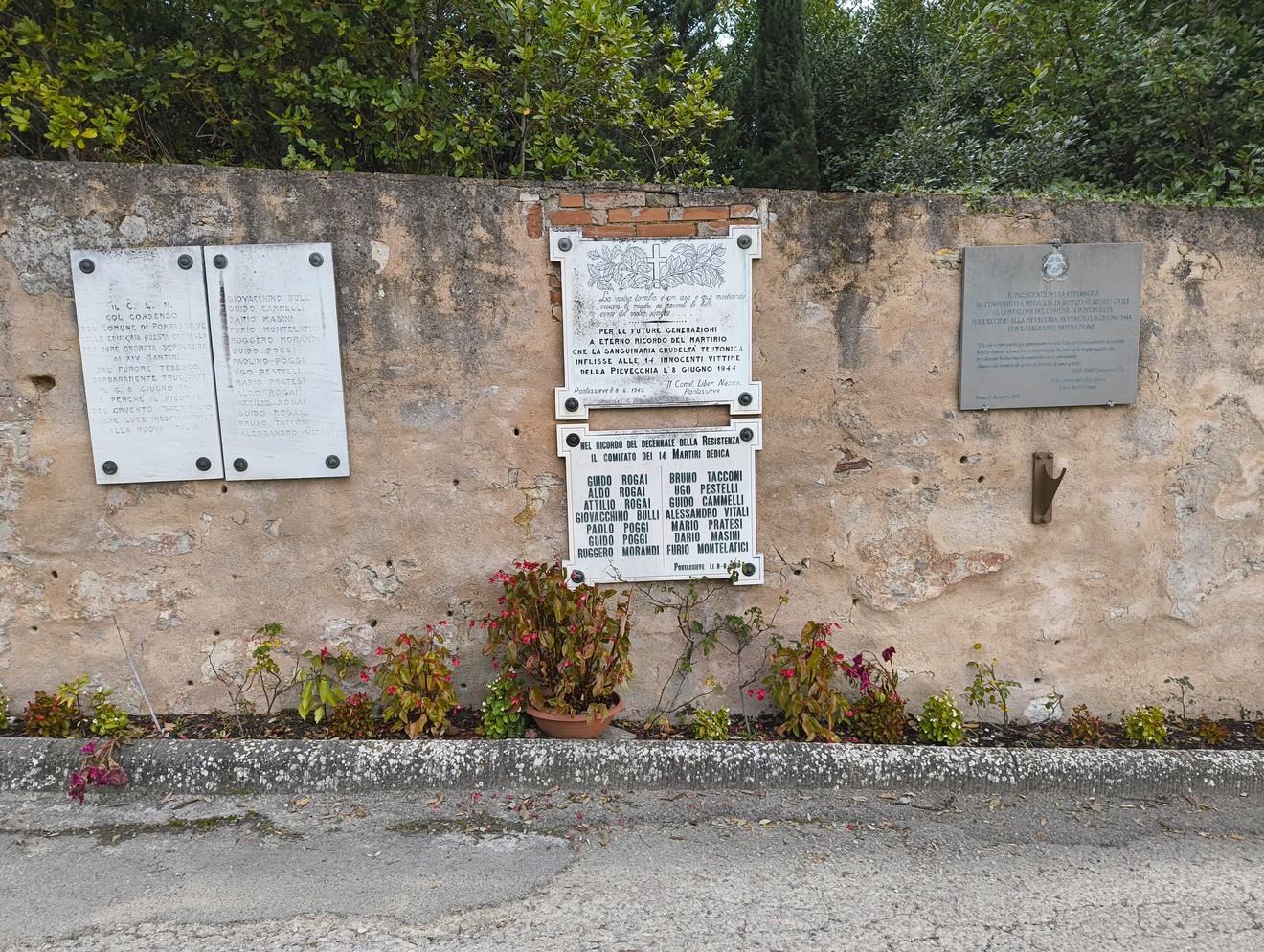 Lapide di Pievecchia, memoriale storico con iscrizioni su parete rocciosa, circondata da vegetazione.
