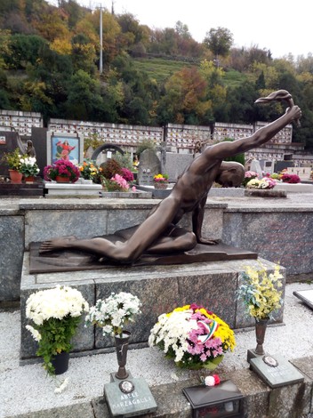 Monumento ai caduti della resistenza di Mandello, con una scultura e fiori commemorativi.