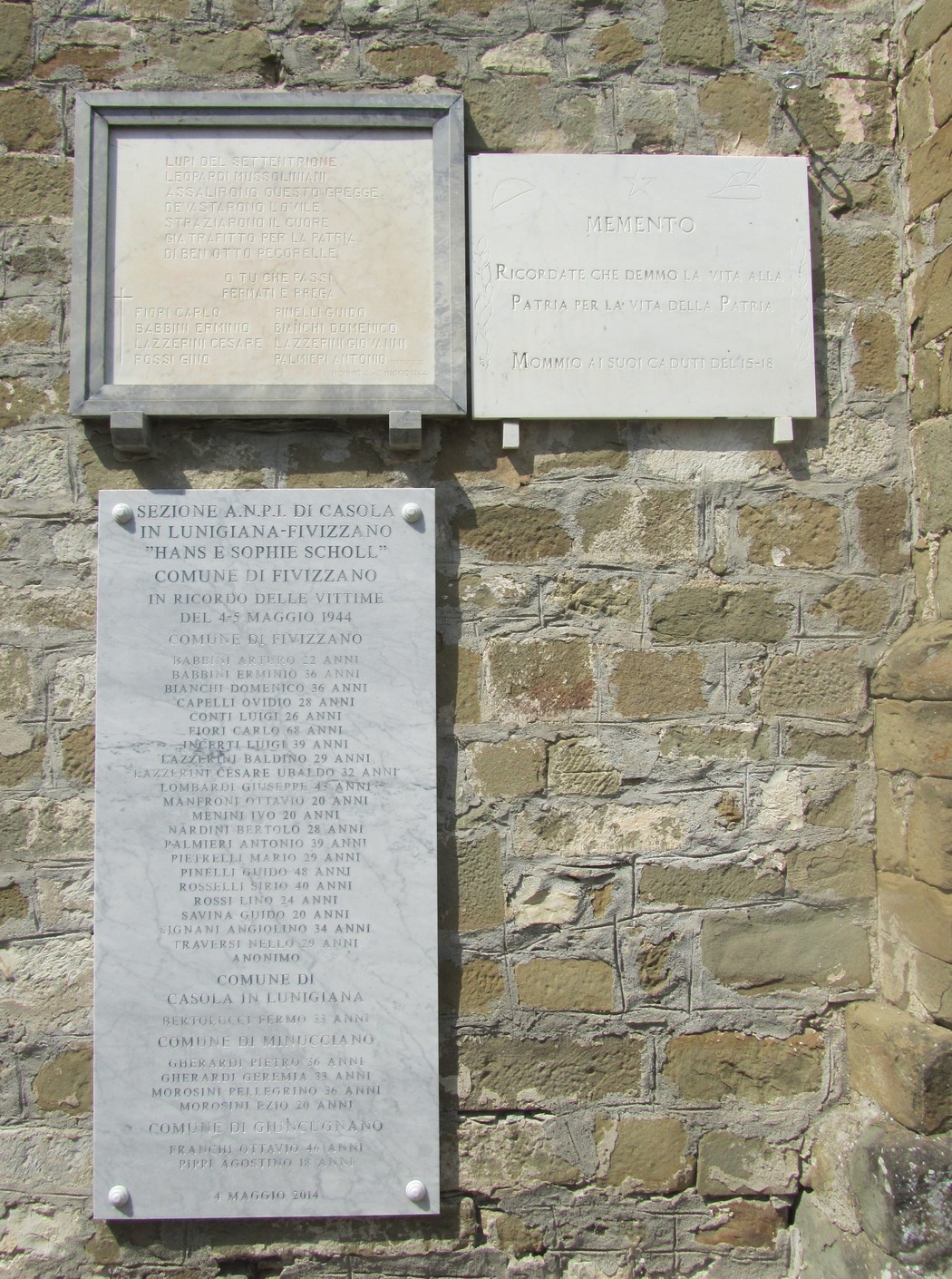 Lapide commemorativa in pietra dedicata alla strage di Mommio, con iscrizioni e nomi delle vittime.