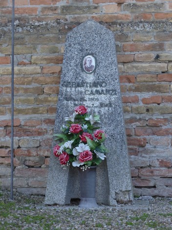 Cippo commemorativo a Camanzi con decorazione floreale, testimonianza di una memoria storica.